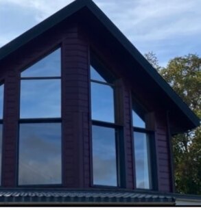 Baie vitrée de chalet équipée d’un film de vitrage, pignon vitré traité sans dépose des menuiseries